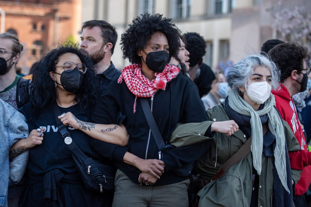 Pro-Palestinian protesters link arms as police take down the encampment set up at Library Mall on the UW-Madison campus on May 1, 2024. Angela Major/WPR