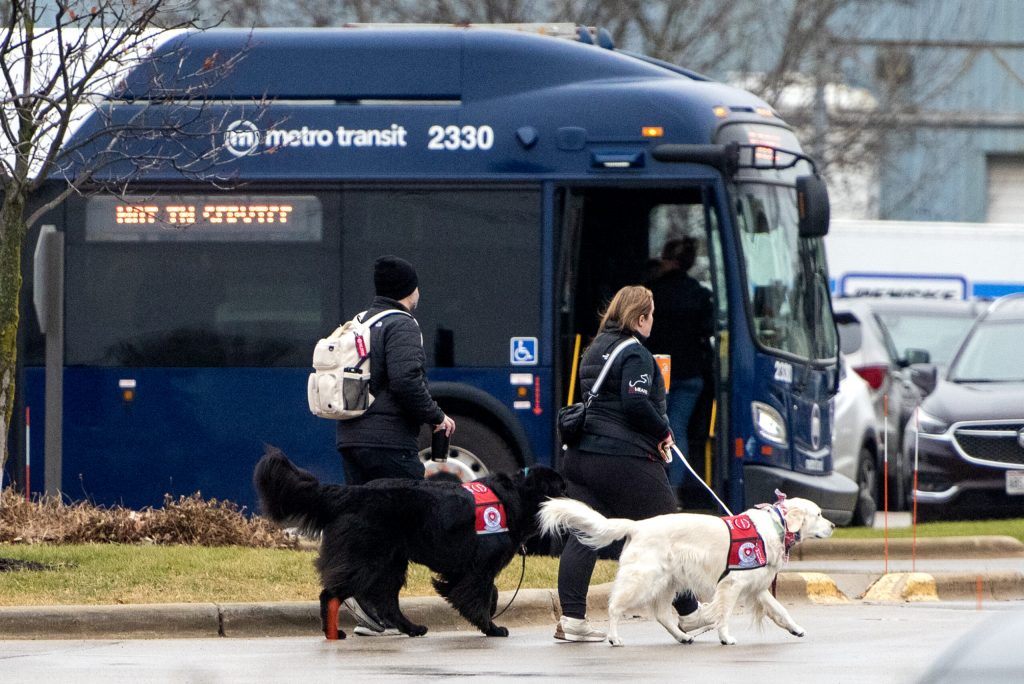 Dogs walk into the area where Abundant Life Christian School students will be reunified with their parents Monday, Dec. 16, 2024, in Madison, Wis. Angela Major/WPR