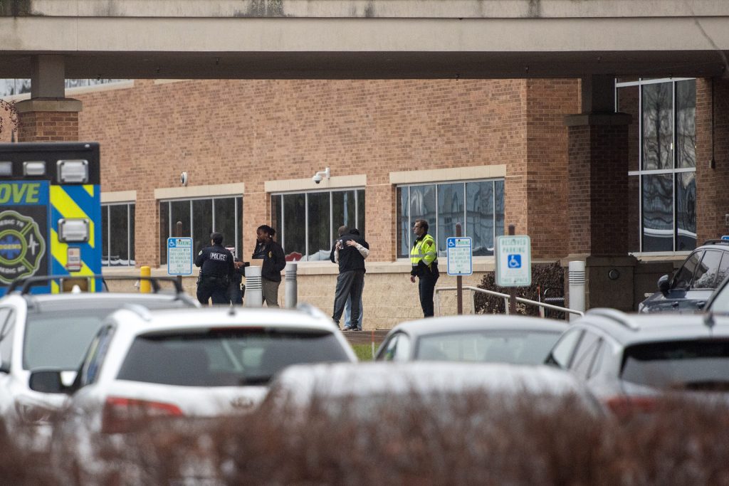 People stand outside of a hospital serving as the reunification center for Abundant Life Christian School students and parents Monday, Dec. 16, 2024, in Madison, Wis. Angela Major/WPR