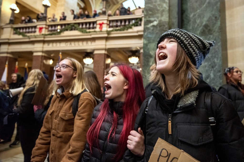 People participate in a walkout and protest led by West High School students in response to the Abundant Life Christian School shooting Friday, Dec. 20, 2024, at the Wisconsin State Capitol in Madison, Wis. Angela Major/WPR