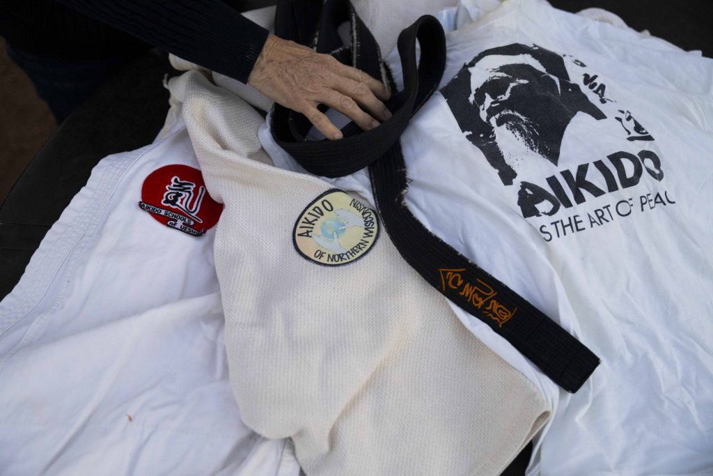 Dora Gorski looks through aikido keepsakes from her late husband Ken in Wausau, Wis. While moving into Pine Crest Nursing Home in Merrill, Wis., where he spent the end of his life, Ken interacted with multiple people who knew him from his days as an aikido instructor. (Joe Timmerman / Wisconsin Watch)