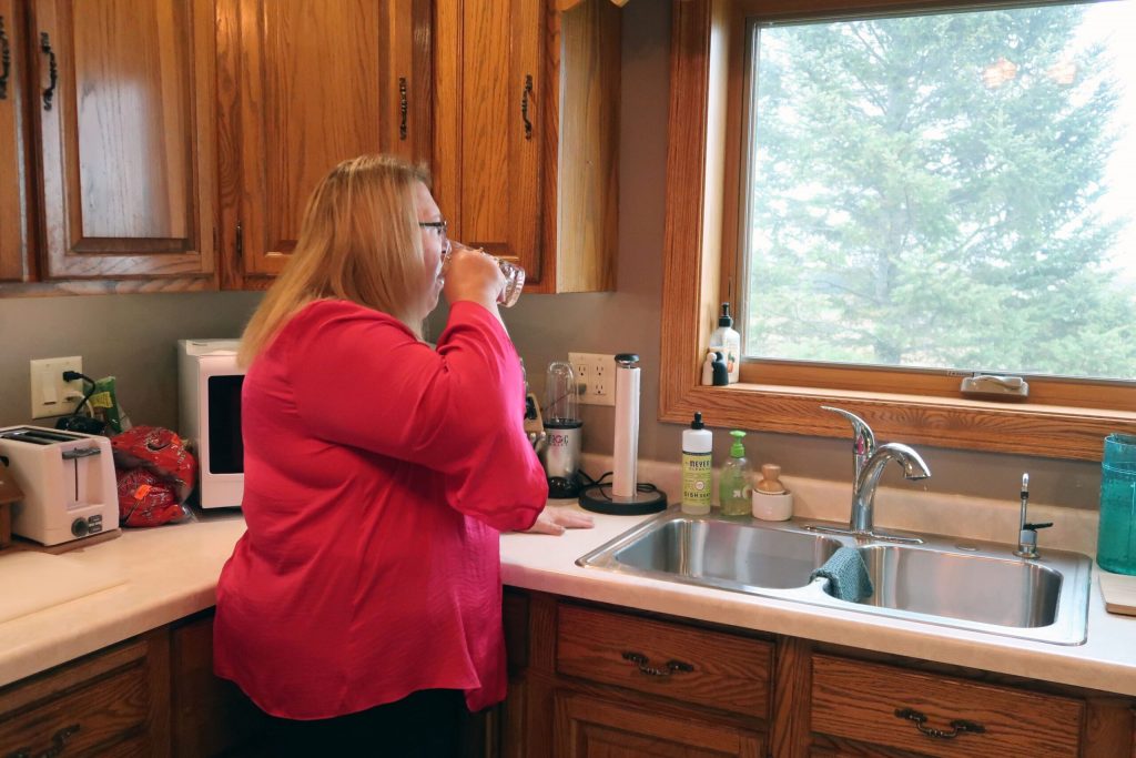 Erika Balza drinks water from a water cooler instead of the faucet because she doesn’t trust her well water is safe from nitrate contamination. Danielle Kaeding/WPR