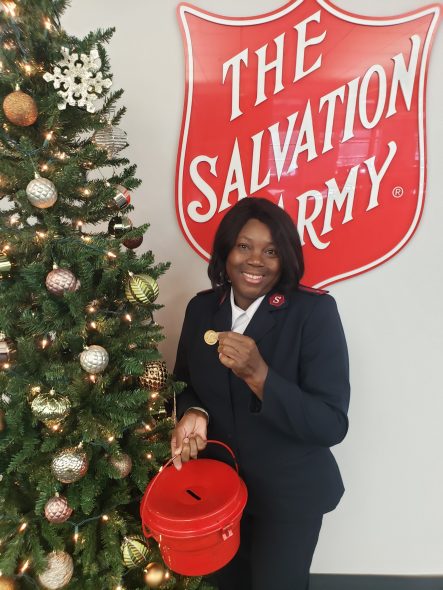 Lt. Donna Gooden holding the gold coin. Photo courtesy of The Salvation Army.