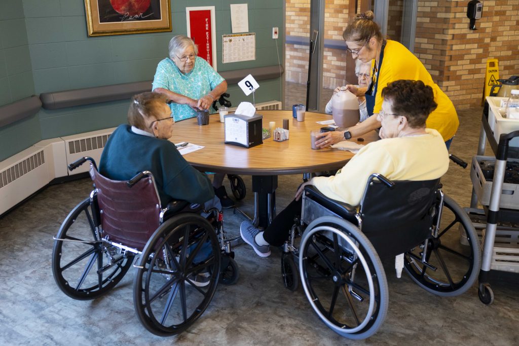 Arlene Meyer, second from left, waits for lunch to be served while sitting with three of her fellow residents — including Florence, left, and Peg, right — at Pine Crest Nursing Home in Merrill, Wis., on Nov. 15, 2024. (Joe Timmerman / Wisconsin Watch)