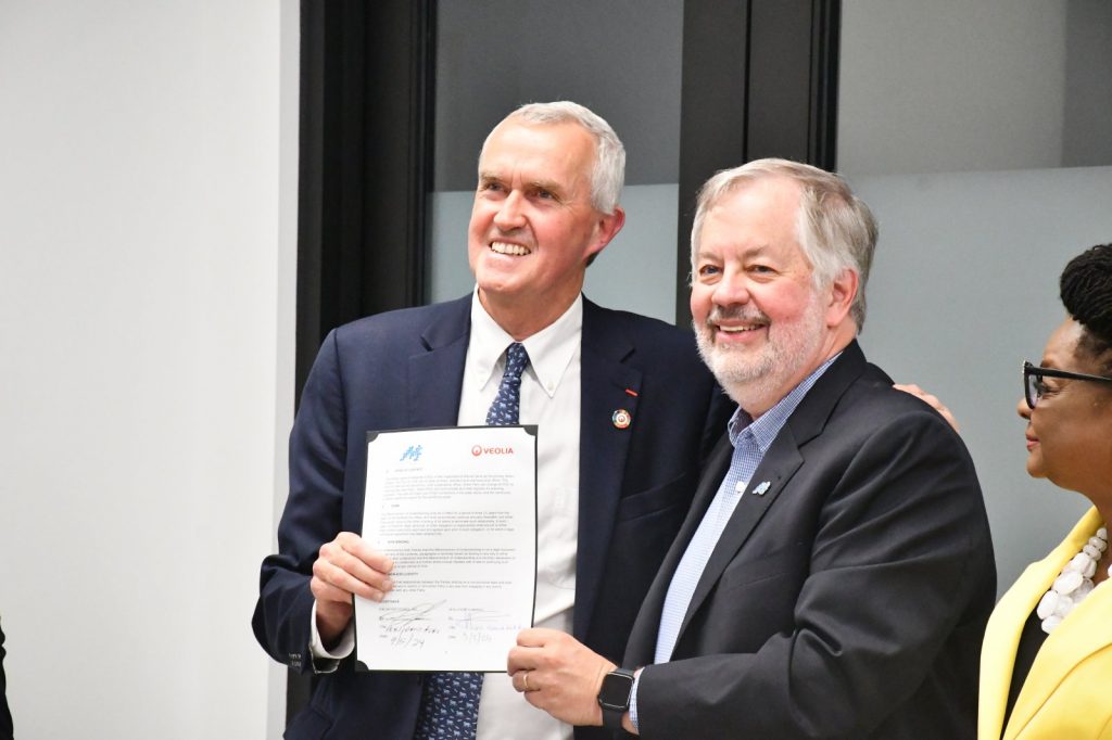 Fred Van Heems of Veolia and Dean Amhaus celebrate the signing of the W+E Forward agreement. Photo by Jeramey Jannene.