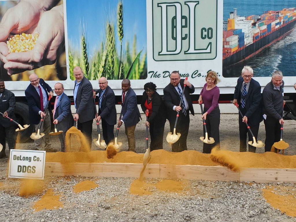 Officials “break ground” on Port Milwaukee’s new DeLong Agricultural Maritime Export Facility on Wednesday. While construction has not yet started, the crew dug into a bin of dry distiller’s grain, which will be one of the main exports from the new facility. Christine Hatfield/WPR