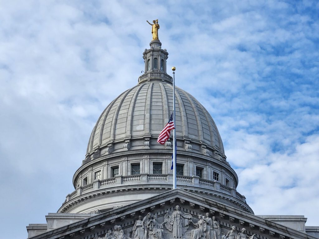 The U.S. and Wisconsin flags at half staff in commemoration of those killed and wounded in a December school shooting in Madison. (Photo by Erik Gunn/Wisconsin Examiner)