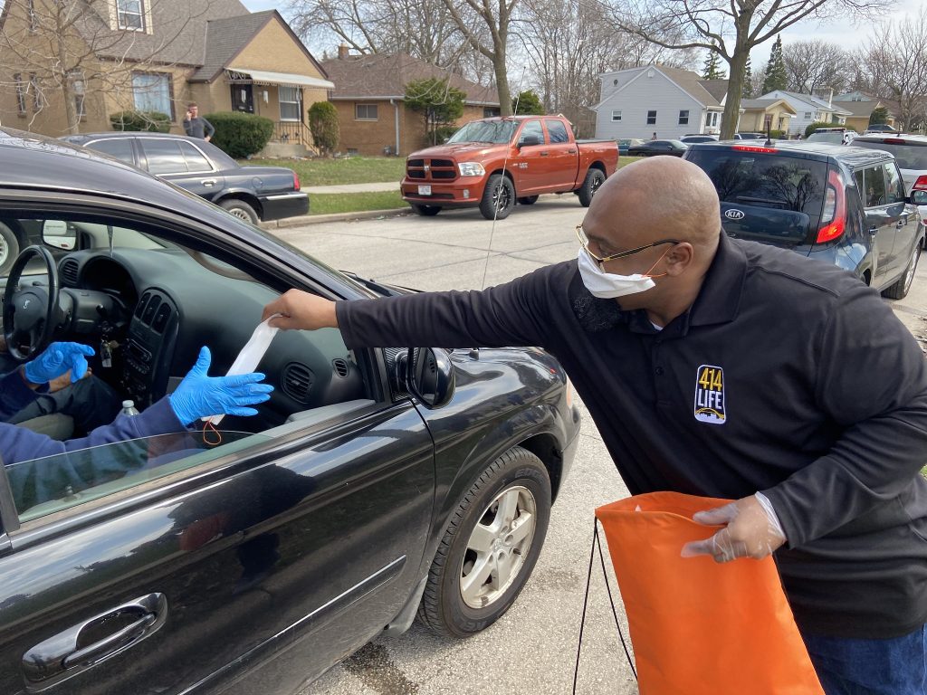 Hamid Abd-Al-Jabbar, right, helps distribute masks in Milwaukee during the pandemic-impacted April 2020 elections. After spending years in prison, Abd-Al-Jabbar found a calling as a peace activist. (Courtesy of City of Milwaukee Office of Violence Prevention)