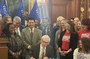 Democratic Gov. Tony Evers signs an executive order on Tuesday, Jan. 14, 2025 to create a statewide office of violence prevention. Sarah Lehr/WPR