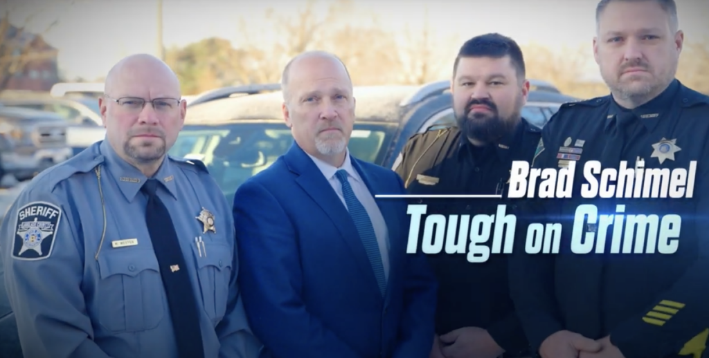 Wisconsin Supreme Court candidate Brad Schimel (second from left) stand next to Chippewa County Sheriff Travis Hakes (second from right), who has been at the center of numerous controversies. (Screenshot)