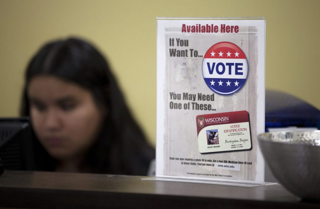 A sign at Union South at the University of Wisconsin-Madison lets students know they may need additional identification to vote in Wisconsin beyond their regular student ID. UW System campuses are offering free specialized voter ID cards, but students will need to also bring proof of enrollment to the polls. Coburn Dukehart/Wisconsin Watch