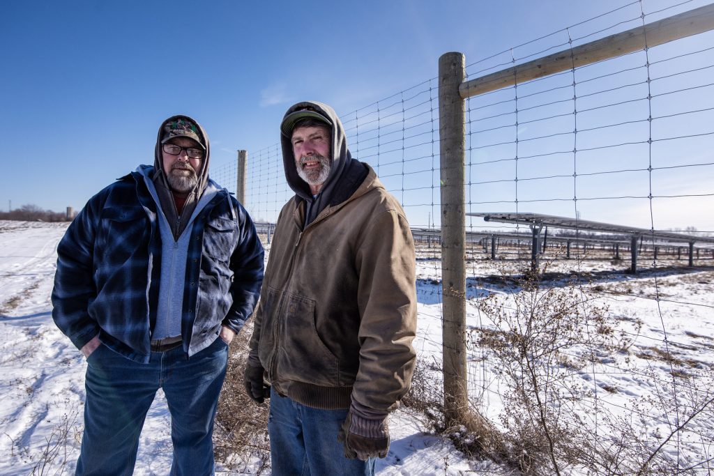 Ed Howell and his brother Bill Howell stand near solar panels on their property Friday, Jan. 24, 2025, in Union Grove, Wis. Angela Major/WPR