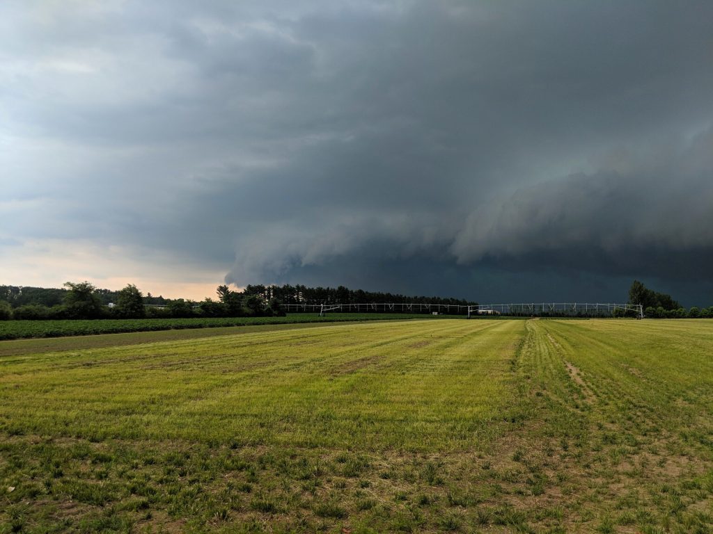 A storm rolls in over a field at Hancock Agricultural Research Station in the Central Sands region of Wisconsin, July 2019. The Midwest Climate Hub provides data and resources to help farmers manage typical and extreme weather events, but the organization’s work has been threatened by the Trump administration’s massive cuts to the federal workforce. Photo courtesy of Tracy Campbell