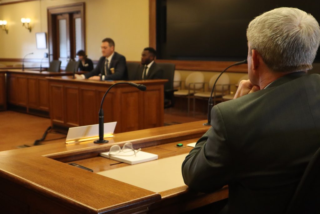 Rep. Rob Hutton (R-Brookfield) watches as Detective Joseph Mensah testifies to the Senate committee. (Photo by Isiah Holmes/Wisconsin Examiner)