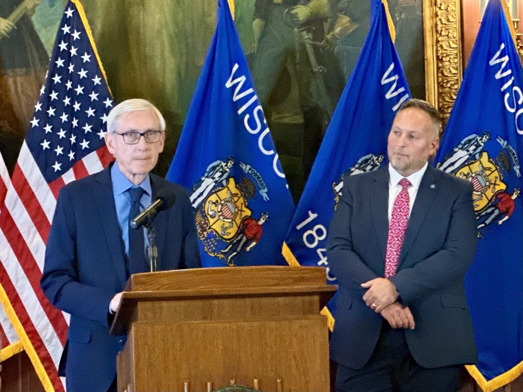 Gov. Tony Evers, left, and Wisconsin Secretary of Corrections Jared Hoy, right, unveil a proposal to shutter the Green Bay Correctional Institution and implement sweeping changes across Wisconsin’s corrections system at a press conference at the state Capitol in Madison, Wis. Anya van Wagtendonk/WPR