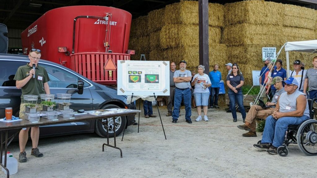 Josh Bendorf presents a rainfall simulation to show how different agricultural land practices absorb rain water at a field day in Watertown in summer 2022. Photo courtesy of Pheasants Forever