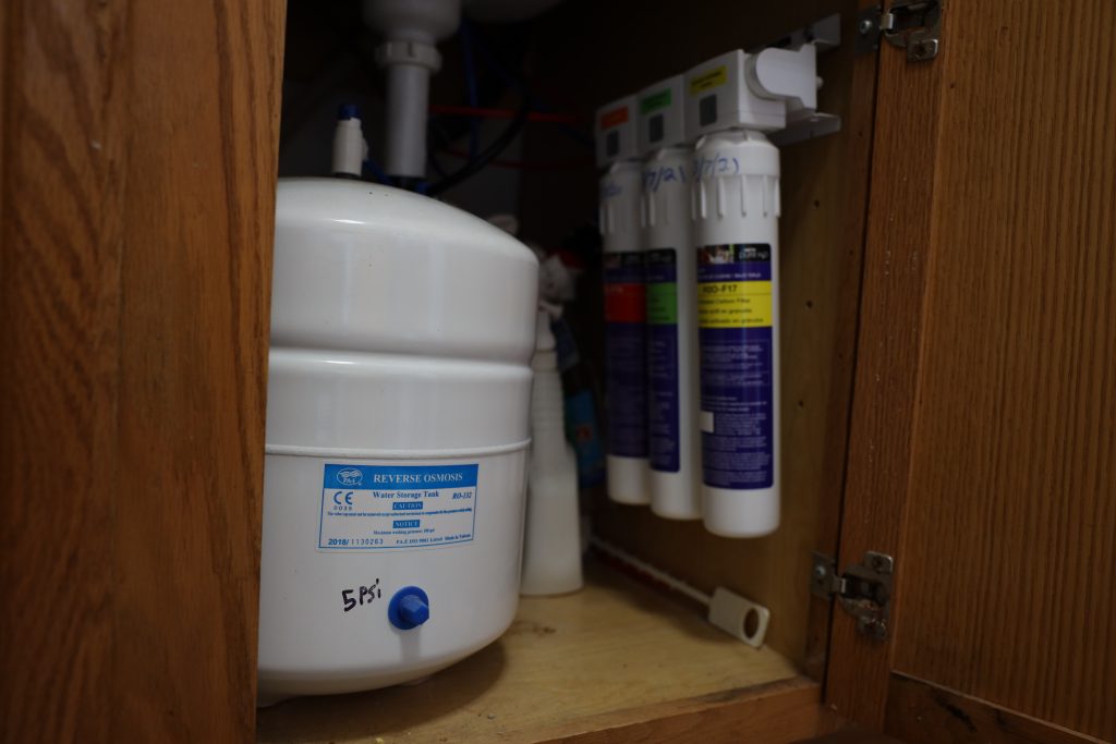 A reverse osmosis filtration system is seen under the kitchen sink of town of Campbell, Wis., supervisor Lee Donahue on July 20, 2022. The household was among more than 1,350 on French Island that had received free bottled water from the city of La Crosse and the state. (Coburn Dukehart / Wisconsin Watch)