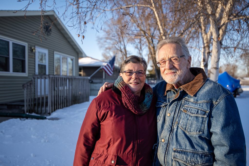 Margie Walker and Jim Boisen stand together outside of their home on French Island on Friday, Feb. 21, 2025, near La Crosse, Wis. Angela Major/WPR