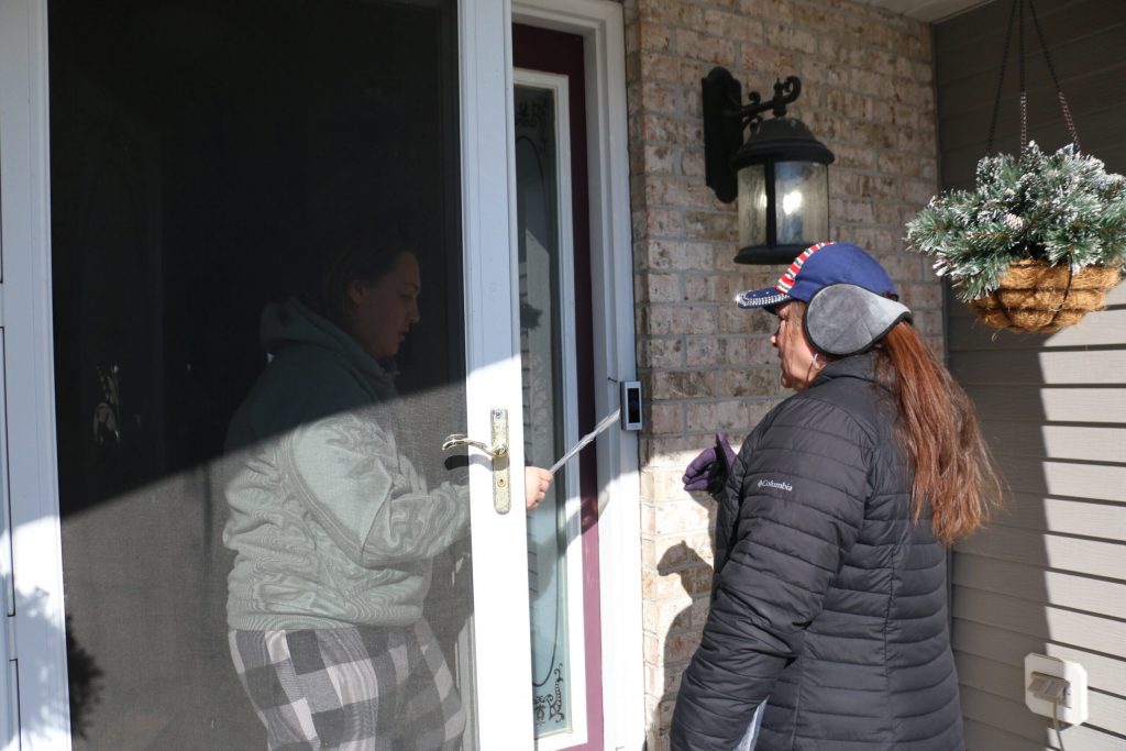 Kenosha County Republican Party volunteer Angela Kretchmer reminds a resident of Wisconsin’s upcoming April 1 election during a day of canvassing. Kretchmer says it’s important to remind voters who cast ballots for President Donald Trump in November that they need to vote in local elections, too. Rich Kremer/WPR