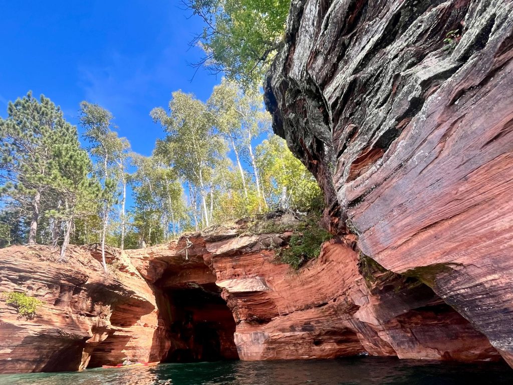 Kayakers take a tour of the sea caves in the Apostle Islands on Sept. 7, 2024. Alyssa Allemand/WPR