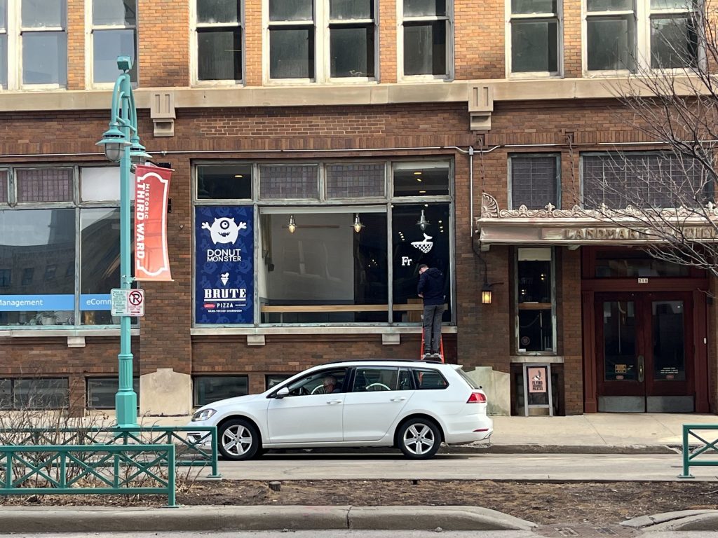 Worker removes sign from FreshFin's Third Ward location, 316 N. Milwaukee St. Photo taken March 10, 2025 by Sophie Bolich.