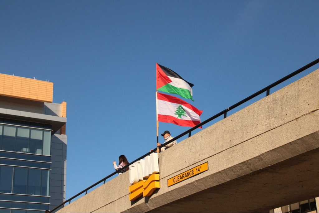 UW-Milwaukee student protesters plant the flags of Palestine and Lebanon on a campus bridge on Maryland Ave. on October 17, 2024. Photo by Caleb Rose.