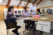 Alix Yarrow, left, registers to vote at the polling place at Olbrich Botanical Gardens in Madison, Wis., on Feb. 18, 2020. (Coburn Dukehart/Wisconsin Watch)