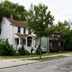 Privately-Owned Homes on 25th St. With City-Owned Home Covered By Tree. Photo taken Aug. 13, 2023 by Jeramey Jannene. All Rights Reserved.
