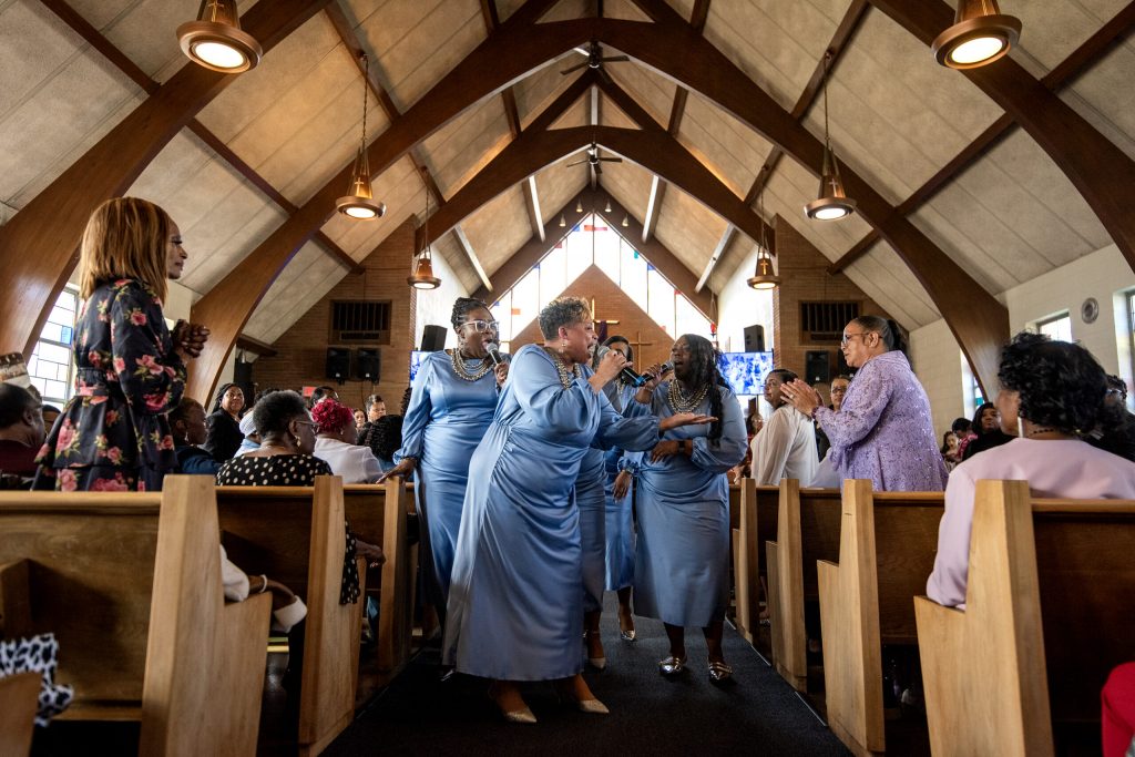 Attendees stand as the O.W.’s Exalters sing Sunday, April 27, 2025, at Holy Temple Firstborn Missionary Baptist Church in Milwaukee, Wis. Angela Major/WPR