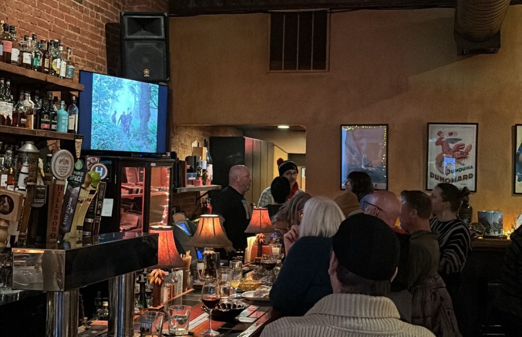 Patrons gather at Maduro Cigar Bar in Madison to watch the 1982 film “Ivanhoe,” an annual New Year’s Day tradition at the indoor cigar and pipe smoking lounge. Lorin Cox/WPR