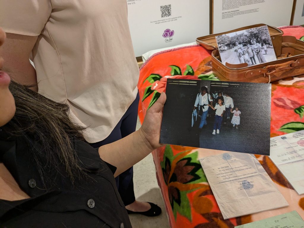 Mai See Thao shows a photo of her family arriving at the Milwaukee airport after their time at a refugee camp in Thailand. Richelle Wilson/WPR