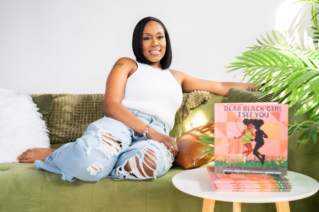 Milwaukee-based children’s book author Ebony Haynes poses with her new book, “Dear Black Girl: I See You.” Photo courtesy Ebony Haynes