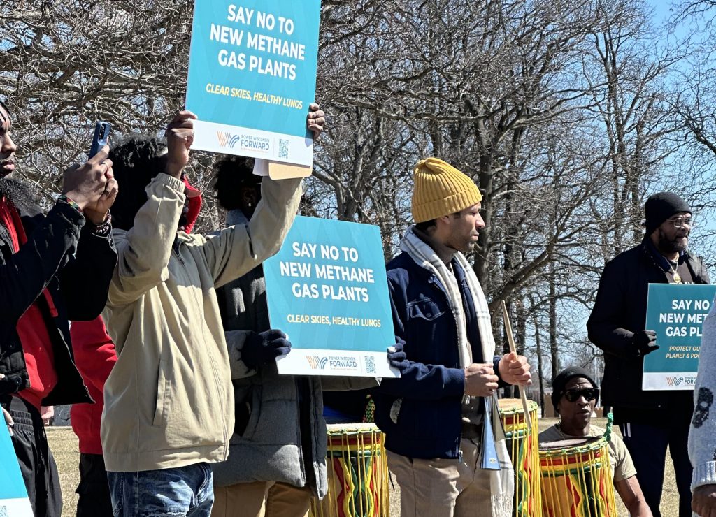 People hold signs calling on the Public Service Commission to deny the approval of a new natural gas plant in Oak Creek ahead of a public hearing on the project Tuesday, March 25, 2025. Photo courtesy of Sierra Club Wisconsin