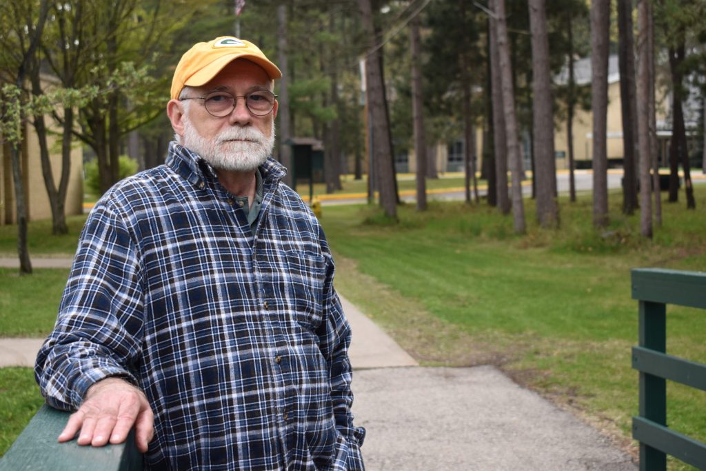 Marinette Common Council member Doug Oitzinger stands over a ditch flowing into Green Bay where water samples have shown PFOS levels as high as 2,000 parts per trillion before it’s treated. Danielle Kaeding/WPR