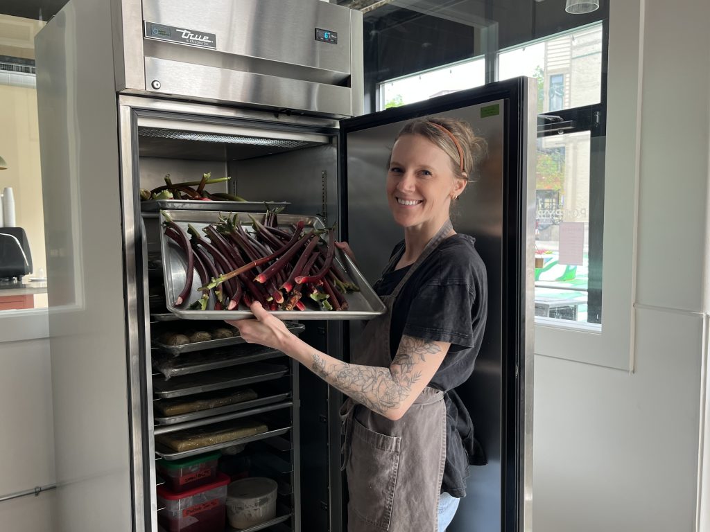 Amy Gorski, owner of Poppy Bakery, shows off a stash of fresh rhubarb. Photo taken June 13, 2025 by Sophie Bolich.