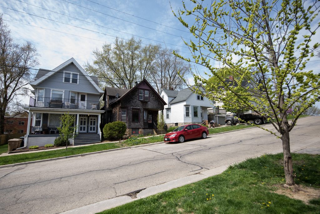 A car drives by homes in a neighborhood Friday, May 5, 2023, in Madison, Wis. Angela Major/WPR
