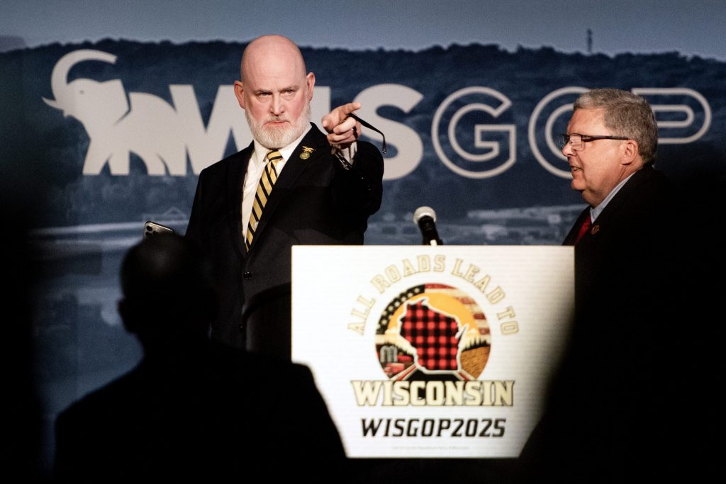 US Rep. Derrick Van Orden prepares to take a selfie with the crowd at the beginning of his remarks Saturday, May 17, 2025, at the Republican Party of Wisconsin State Convention in Rothschild, Wis. Angela Major/WPR
