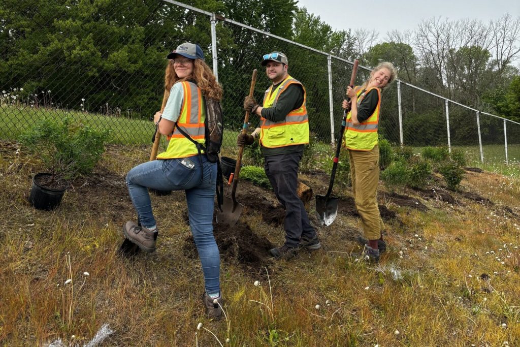 Green Bay Conservation Corps workers, from left, Emily Swagel, Zak King and Cailie Kafura, plant native shrubs in Fireman’s Park. The work is part of installing a pollinator corridor and a larger land restoration project across Green Bay. (Photo courtesy of Green Bay Conservation Corps)