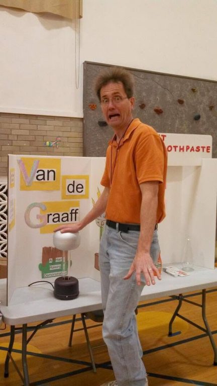 American Science & Surplus owner Patrick Meyer puts his hand on a Van de Graaff generator. Photo courtesy of Patrick Meyer