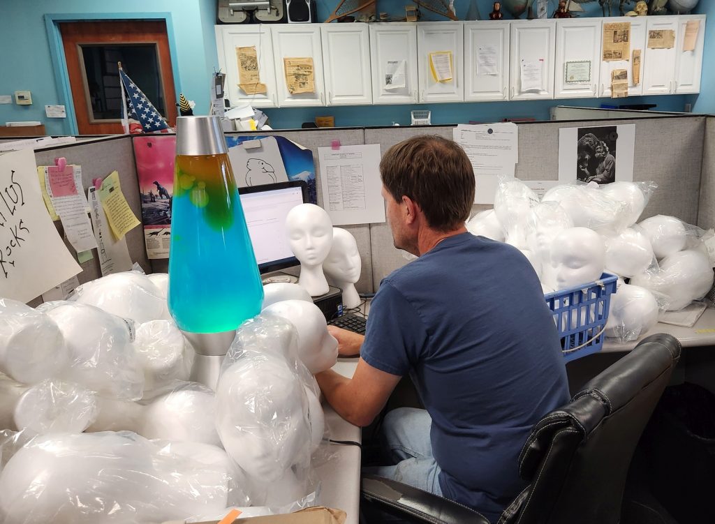 American Science & Surplus owner works alongside more than a dozen mannequin heads. Photo courtesy of Patrick Meyer