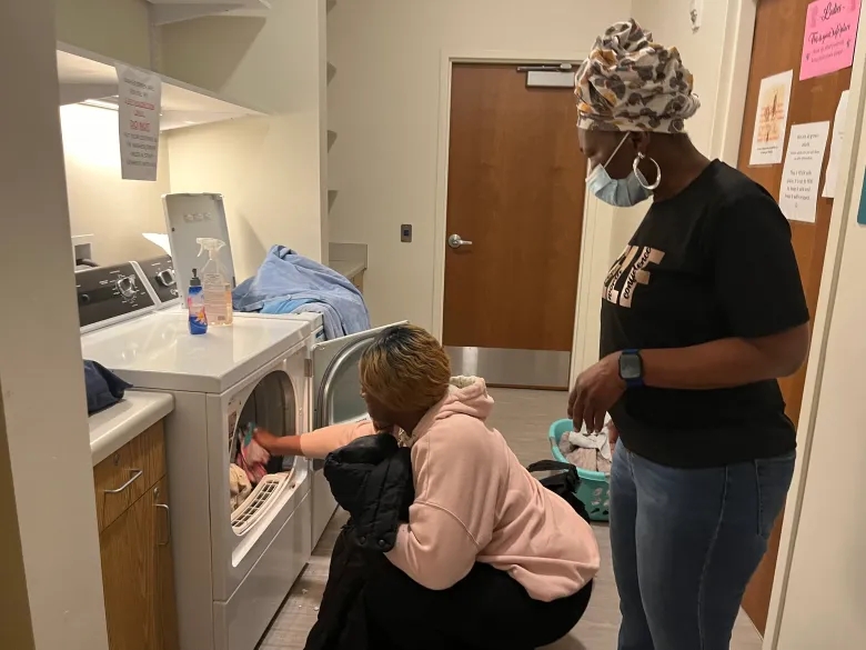 A staffer helps a woman with laundry at the Benedict Center’s North Avenue drop-in center. The drop-in centers had more than 4,000 visitors in 2024. (NNS File Photo)
