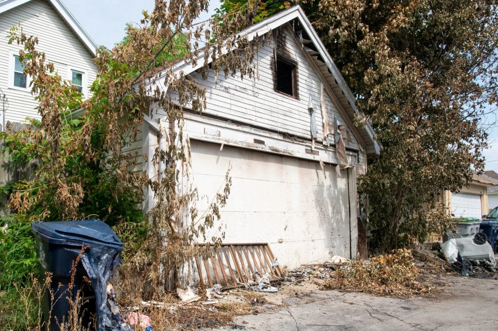 The fire on North 53rd Street also damaged this garage and destroyed several garbage carts. (Photo by Jonathan Aguilar / Milwaukee Neighborhood News Service / CatchLight Local)