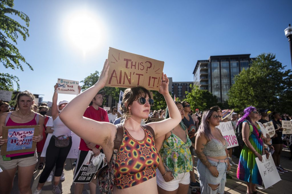 Protesters stand with signs in opposition to the Supreme Court’s decision to overturn Roe vs. Wade on Friday, June 24, 2022, in Madison, Wis. Angela Major/WPR