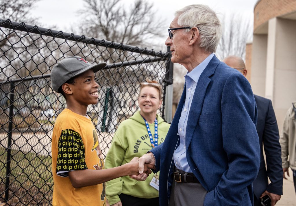 Gov. Tony Evers shakes hands with an 8th grade student Wednesday, Nov. 9, 2022, during a visit to Georgia O’Keeffe Middle School in Madison, Wis. Angela Major/WPR
