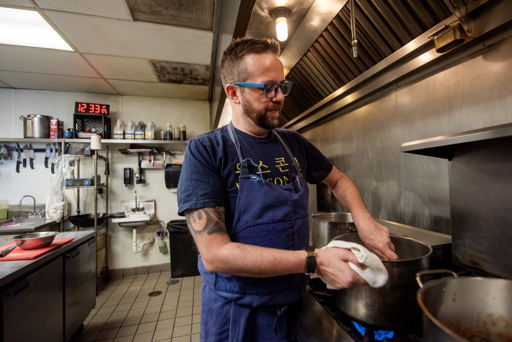 Dan Jacobs preps food in the kitchen Friday, March 1, 2024, at DanDan, a Milwaukee restaurant he co-owns. (Angela Major/WPR)