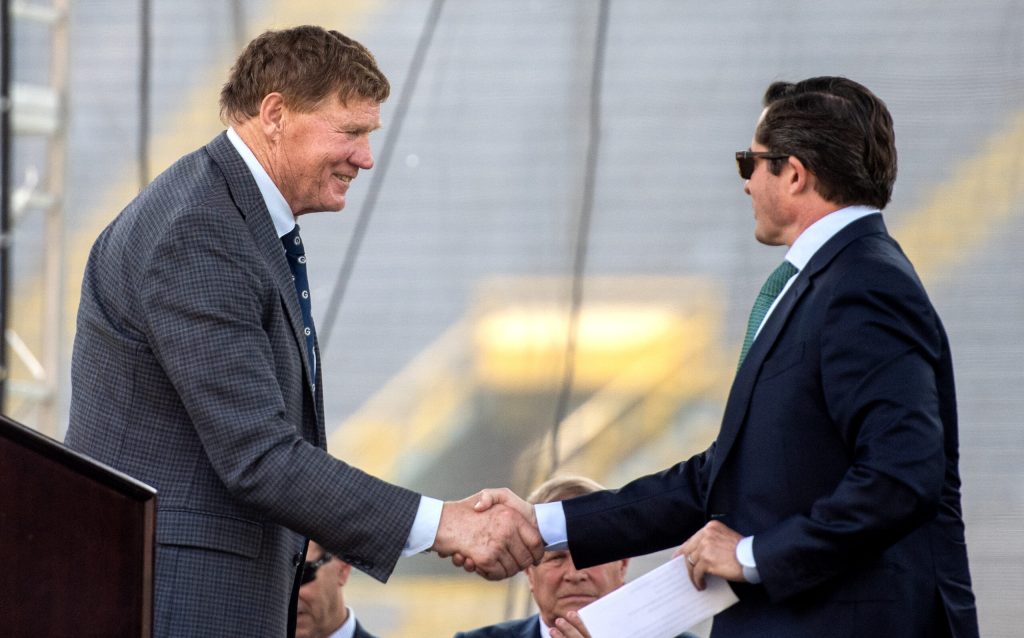 Outgoing Green Bay Packers President and CEO Mark Murphy, left, shakes hands with incoming Green Bay Packers President and CEO Ed Policy, right, during the team’s annual meeting of shareholders Friday, July 25, 2025, at Lambeau Field in Green Bay, Wis. Angela Major/WPR