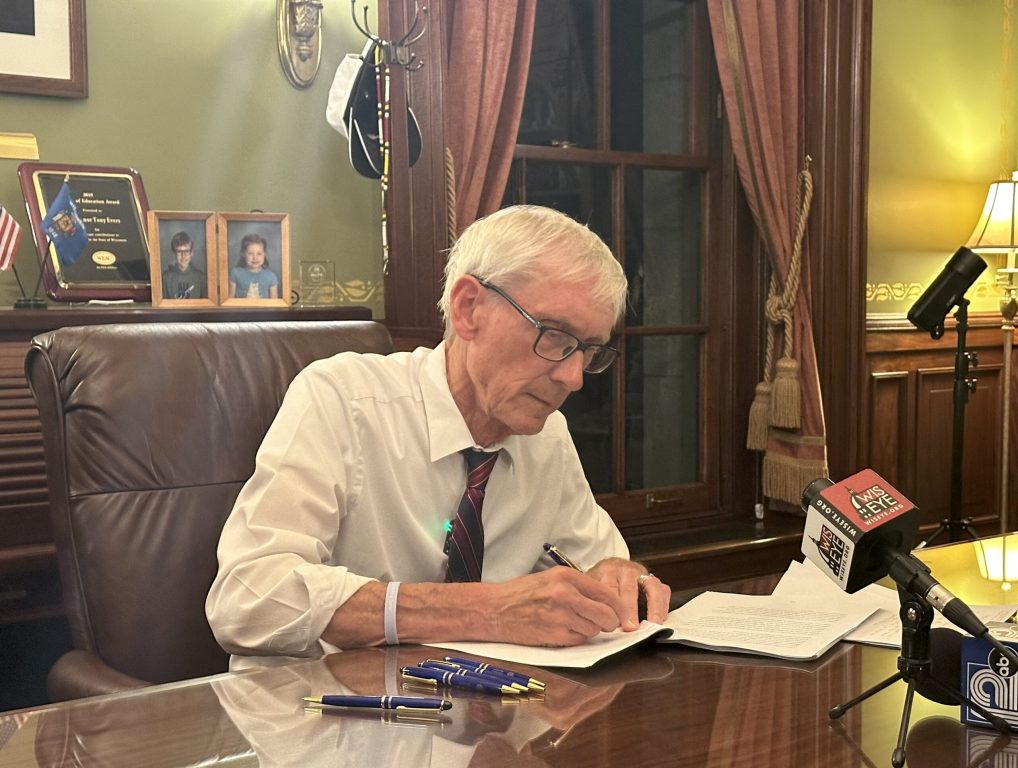 Gov. Tony Evers signs the 2025-2027 Wisconsin state budget into law early on Thursday, July 3, after an all day and night debate in the state Senate and Assembly, in his office at the Wisconsin State Capitol, in Madison, Wis. Anya van Wagtendonk/WPR