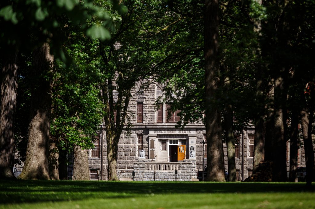 Green Bay Correctional Institution’s front door reads “WISCONSIN STATE REFORMATORY,” a nod to its original name, in Allouez, Wis., on June 23, 2024. Many have pushed for the closure of the prison, constructed in 1898, due to overcrowding and poor conditions. The latest two-year state budget appropriates funding to plan its replacement. (Julius Shieh / Wisconsin Watch)