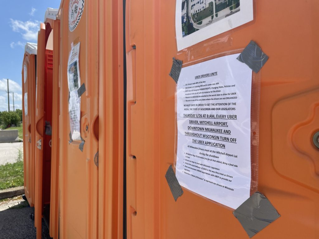 Flyers calling for a drivers’ strike on portable toilets at Milwaukee Mitchell International Airport’s rideshare staging lot on June 27, 2025. Nick Rommel/WPR