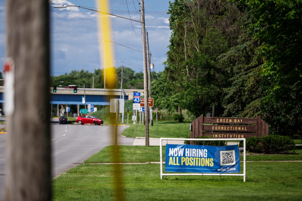 A Wisconsin Department of Corrections advertisement of open prison staffing positions is seen near Green Bay Correctional Institution in Allouez, Wis., on June 23, 2024. Staffing vacancies are again climbing in Wisconsin prisons following initial progress. (Julius Shieh / Wisconsin Watch)